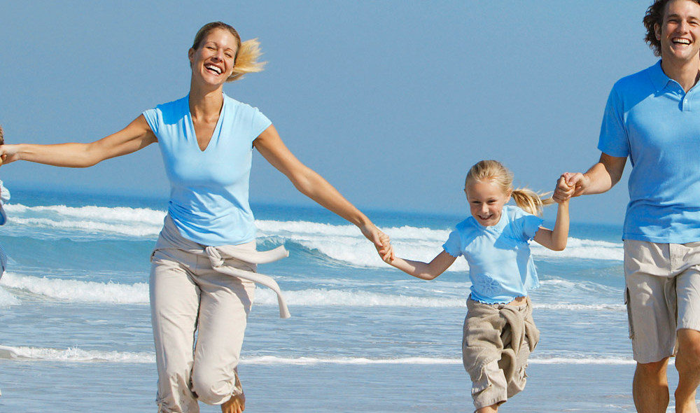Ouders en kinderen vrolijk rennend op het strand