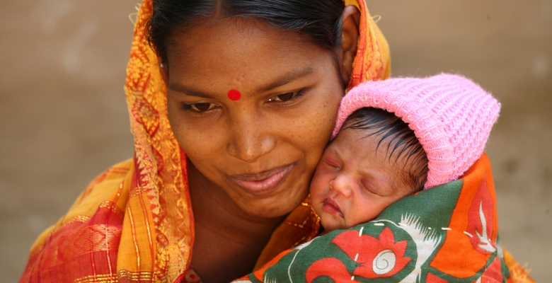 Indiase moeder met baby in oranje omslagdoek. Eindelijk volwassen! Help het kind in je opgroeien naar volwassenheid.