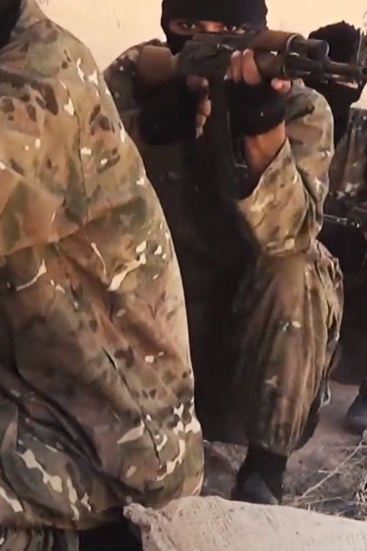 IS strijders in een trainingskamp zitten achter een muur met geweren. Hoe moeten we reageren op terreur, als vrede is wat we willen?