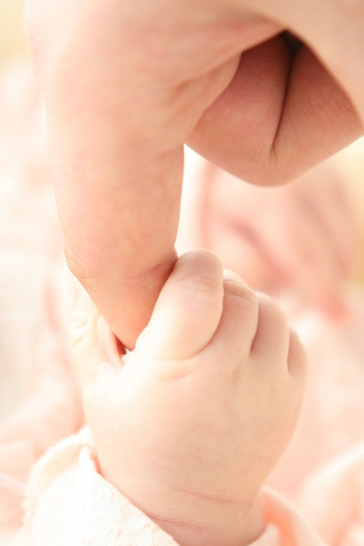 Een waardig en compleet leven in eenheid: baby grijpt vinger van pappa